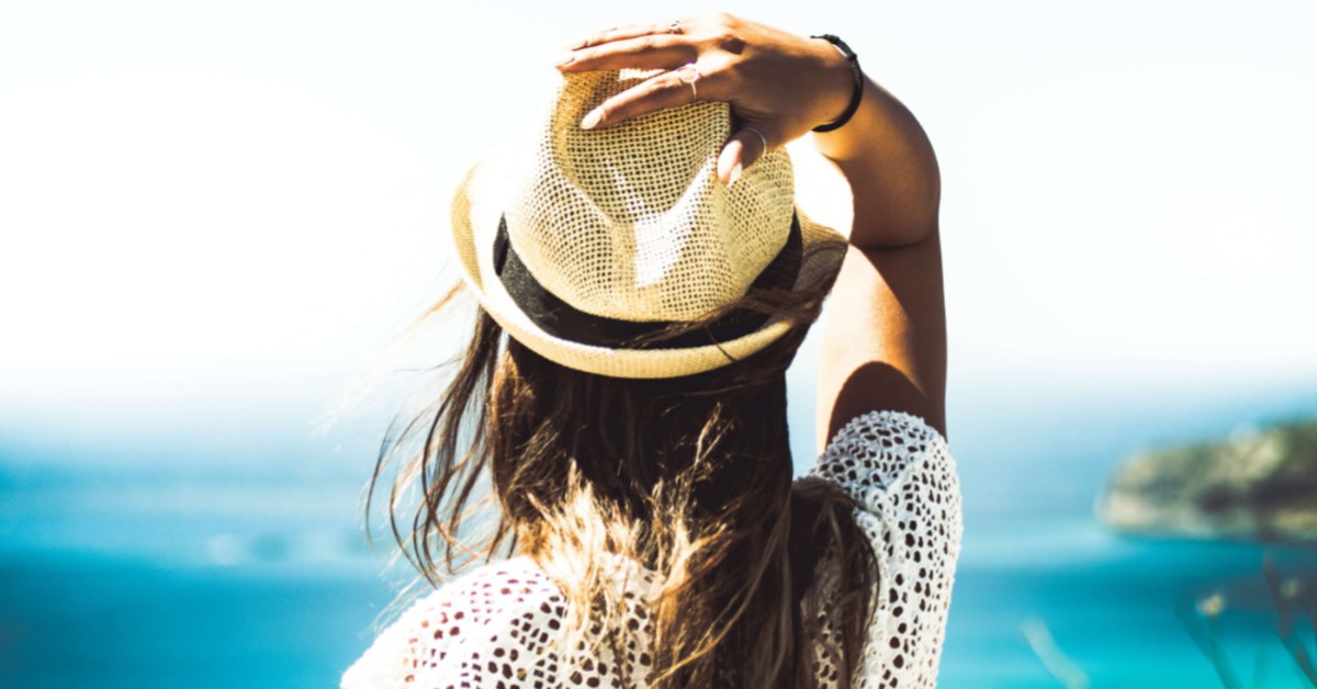 Image of woman on a beach with a hat