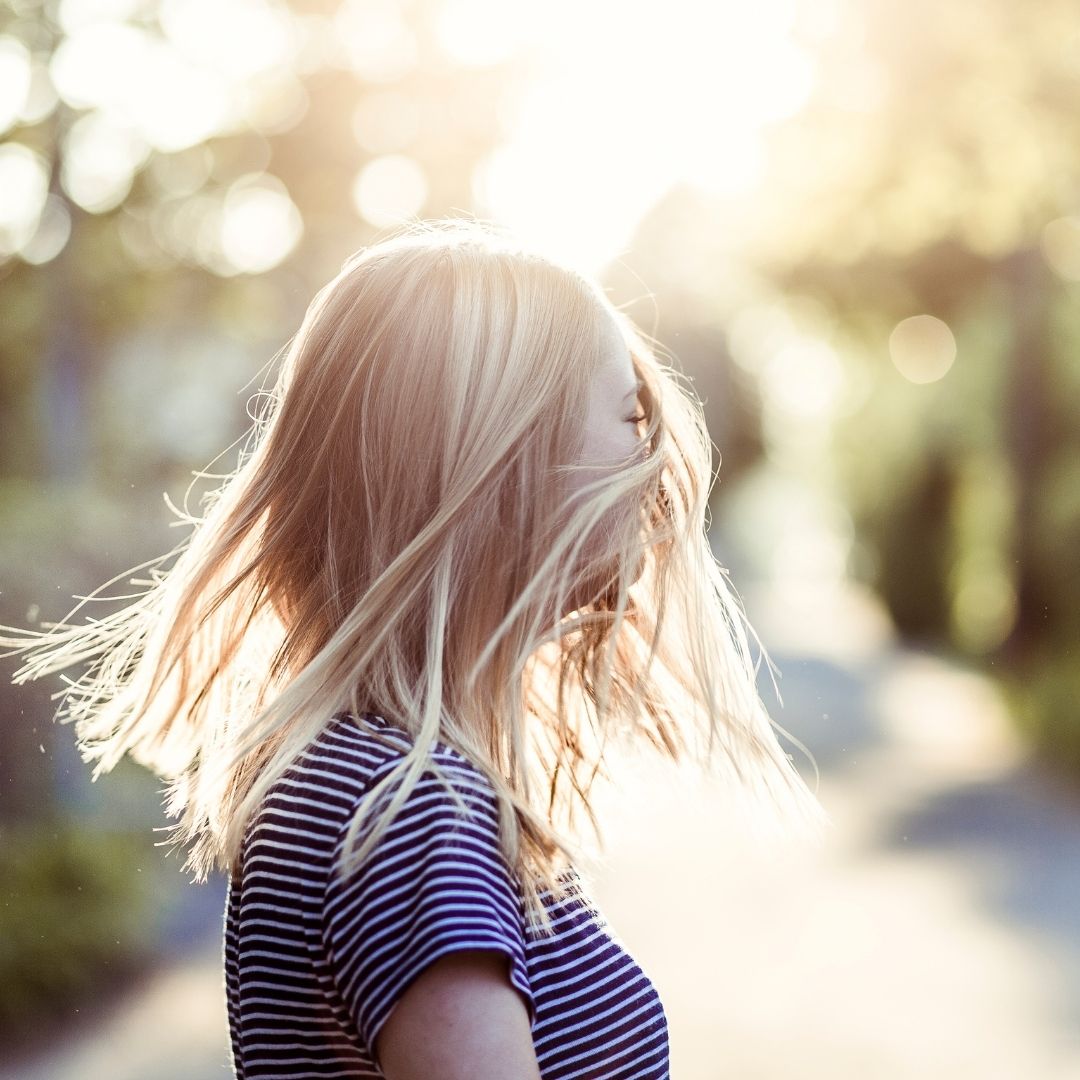 A woman with her heir shinning with sun rays.